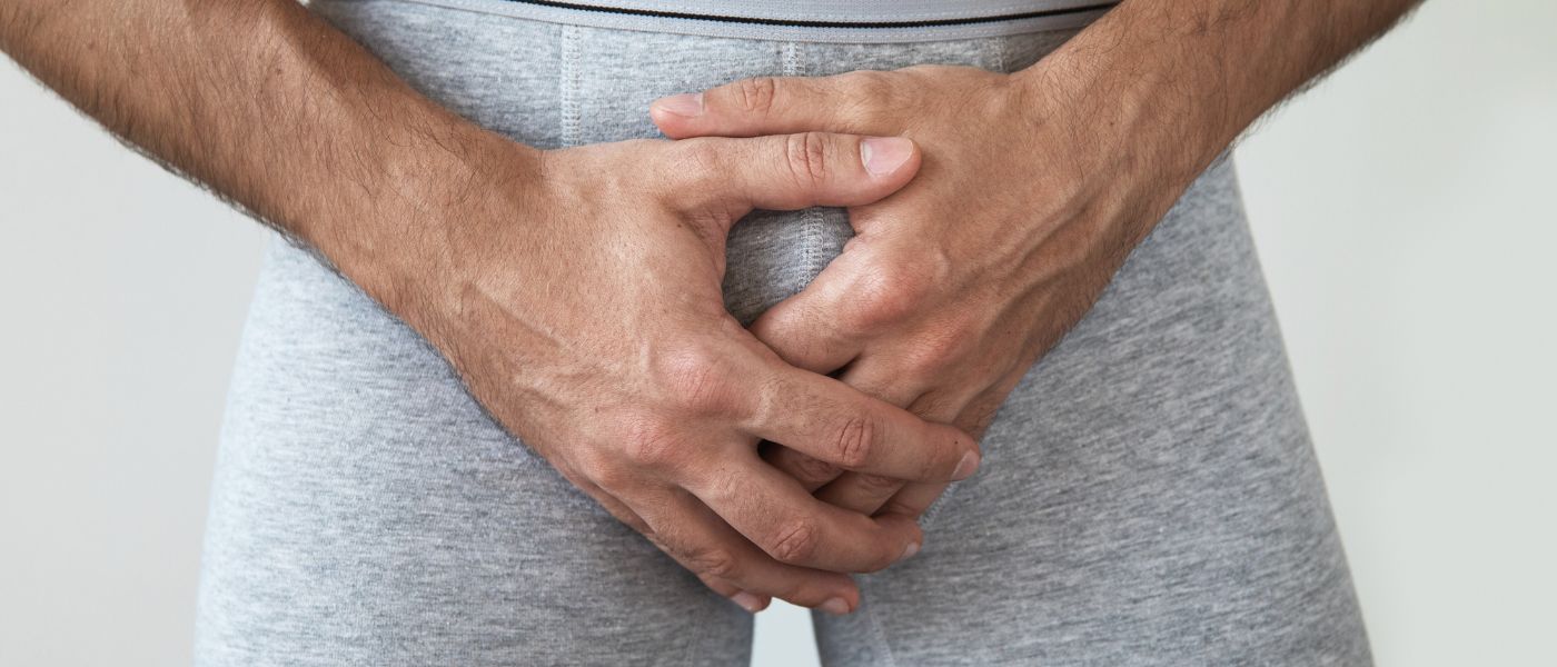 man-met-grijze-boxer-die-zijn-penis-vasthoudt