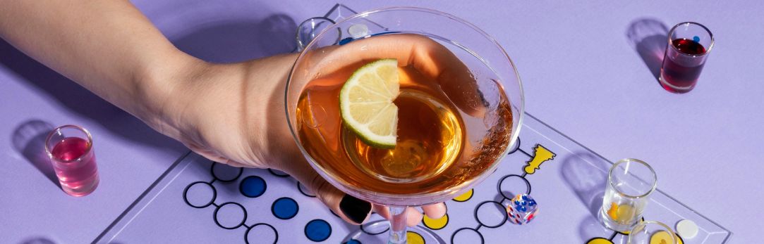bordspel op paarse achtergrond met cocktail en shotjes