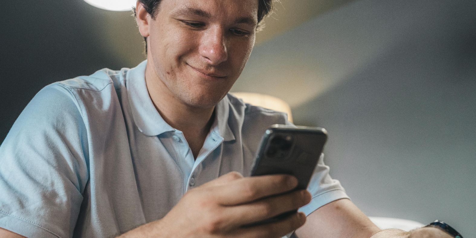 jongen-lacht-naar-zijn-telefoon