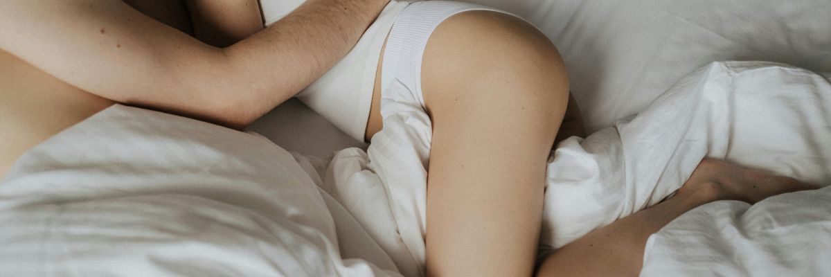 koppel-knuffelend-in-bed-met-deken