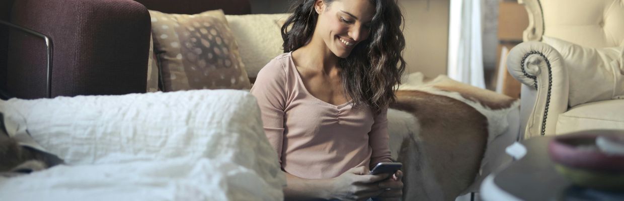 vrouw-die-vrolijk-op-haar-telefoon-kijkt