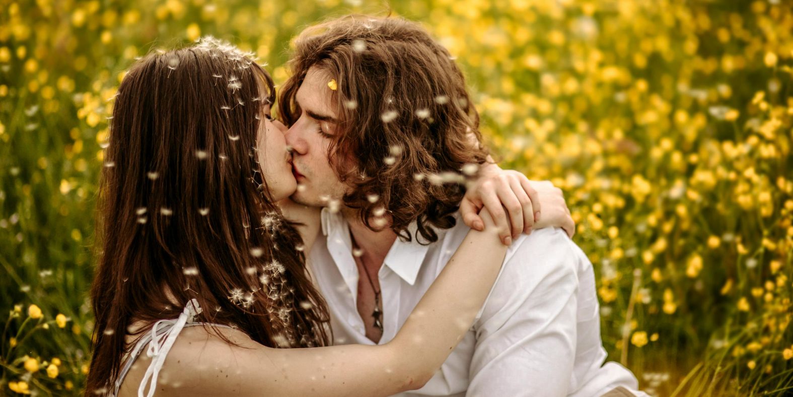 twee-mensen-zoenen-bij-een-bloemenveld